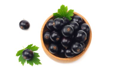 ahşap kase yeşil yaprak beyaz arka plan üzerinde izole siyah frenk üzümü. üstten görünüm