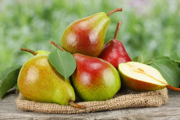 pear with leaf on old wooden table with garden background