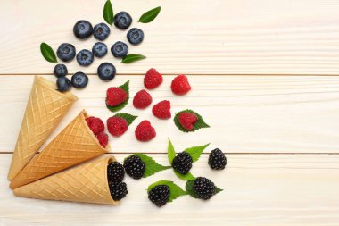 yaban mersini, böğürtlen, ahududu ahşap masa lambası arka plan üzerinde dondurma koni karışımı. kopya alanı ile üstten görünüm