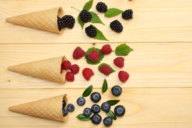 yaban mersini, böğürtlen, ahududu ahşap masa lambası arka plan üzerinde dondurma koni karışımı. kopya alanı ile üstten görünüm