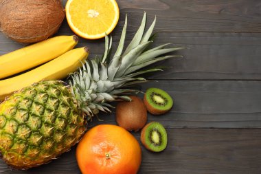 taze Hindistan cevizi, muz, kivi, portakal ve koyu ahşap arka plan üzerinde ananas karışımı. kopya alanı ile üstten görünüm