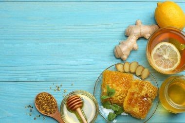 sağlıklı arka plan. Tatlım, petek, limon, çay, mavi ahşap masaya zencefil. Kopya alanı ile üstten görünüm