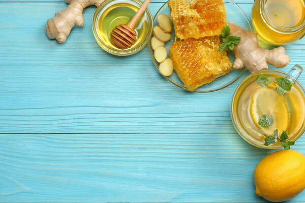 здоровый фон. мед, соты, лимон, чай, имбирь на голубом деревянном столе. Вид сверху с пространством для копирования
