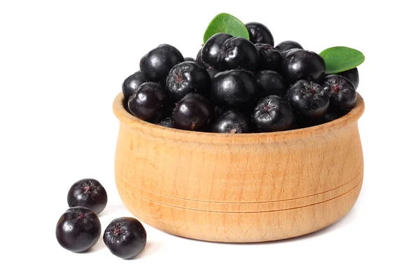 Chokeberry dans un bol en bois avec des feuilles vertes isolées sur fond blanc. Aronia noire — Photo