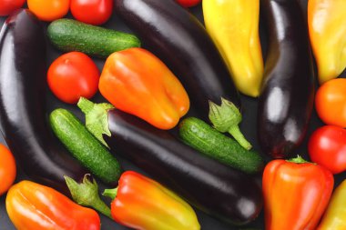 Siyah arka plan üzerinde taze çiğ sebze çeşitleri. Domates, patlıcan, soğan, biber, maydanoz, baharat. Üstte görüntü 