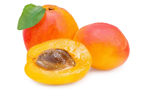 Dilimlenmiş kayısı meyveleri ve beyaz arka planda izole edilmiş yeşil yaprak. tam alan derinliği