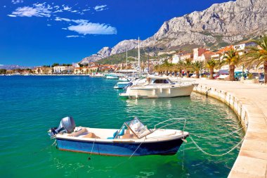 Hırvatistan 'ın Dalmaçya bölgesinde Biokovo dağı manzarası altında renkli Makarska tekneleri ve liman manzarası