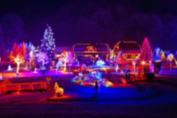 在美丽的雪夜 圣诞节灯光下的树木和房屋模糊了视野 — 图库照片