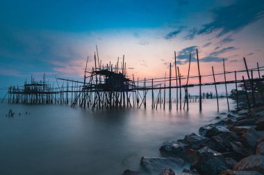 Kumsalda eski iskelede günbatımı. Parit Jabar Batu Pahat Johor siyah & beyaz