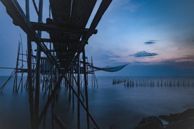 Kumsalda eski iskelede günbatımı. Parit Jabar Batu Pahat Johor siyah & beyaz