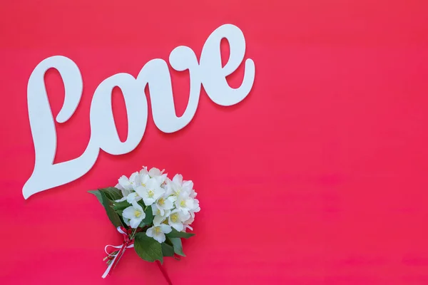 Weiße Buchstaben Die Wortliebe Bilden Geschrieben Mit Jasminblütenstrauß Auf Rosa — Stockfoto