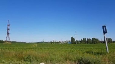 Havai enerji hatları millik elektrik iletim yüksek gerilim kabloları yoluyla oluşan bir tablo oluşturun. Güneşli yaz alanları.