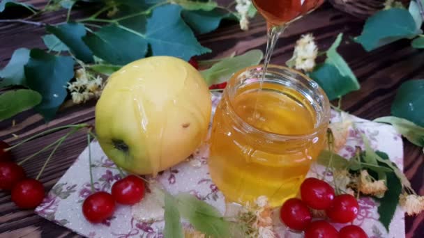 将蜂蜜倒在红苹果上 红苹果片倒在白盘上 蜂蜜与白背景隔离 犹太新年的象征 Rosh Hashanah — 图库视频影像