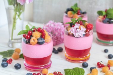 Multivitamin yaz berry lezzetli Panacott. Ahududu, yaban mersini, kuş üzümü, kruton ve nane, pembe ortanca buket, tatlı yiyecek ışık arka plan.