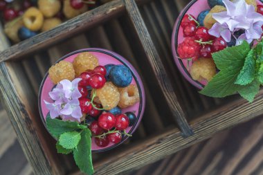 Multivitamin yaz berry lezzetli Panacott. Ahududu, yaban mersini, kuş üzümü, kruton ve nane, pembe ortanca buket, koyu ahşap arka plan, tatlı gıda ana sayfa görünümü.