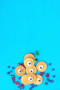 Lezzetli mini kek çilek mavi yüzeyi, üstten görünüm ile gülümse. Düz yatıyordu, en iyi görünümü tatlı gıda arka plan.