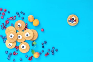 Lezzetli mini kek çilek mavi yüzeyi, üstten görünüm ile gülümse. Düz yatıyordu, en iyi görünümü tatlı gıda arka plan.