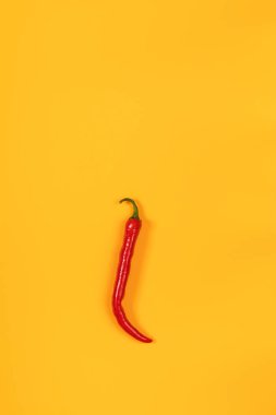 Sarı yüzeyi kırmızı sıcak biber biber. Güzel minimalist gıda sanat arka plan. Üstten görünüm, kopya alanı.