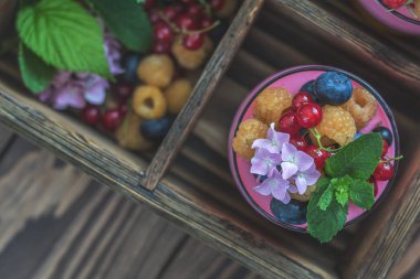 Multivitamin yaz berry lezzetli Panacott. Ahududu, yaban mersini, kuş üzümü, kruton ve nane, pembe ortanca buket, koyu ahşap arka plan, tatlı gıda ana sayfa görünümü.