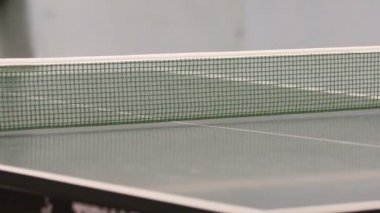 Tablo bir taraftan diğerine seyahat beyaz ping pong topu görebiliriz. Erkek Masa Tenisi oynayan.