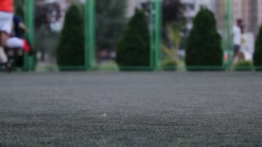 Oynama ve Şehir Parkı alanında futbol aracılığıyla çalışan erkeklerin ayaklarında aut odak kapatın. Sığ derinliği alan, tonda video, 50 kare/sn.