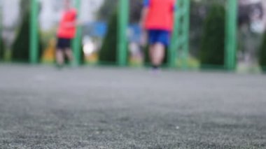 Oynama ve Şehir Parkı alanında futbol aracılığıyla çalışan erkeklerin ayaklarında aut odak kapatın. Sığ derinliği alan, tonda video, 50 kare/sn.