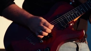 Baş gitarist konser sahnesinde elektro gitar çalıyor.