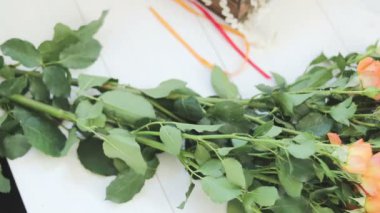 Profesyonel kadın çiçek sanatçı, çiçekçi atölyesinde, çiçekçi dükkanı şerit güzel buket çevresinde kaydırılır. Floristik, el yapımı ve küçük işletme kavramı.