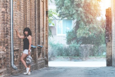 Şirin mutlu güzel seksi esmer erkek bir arka plan günbatımı zamanı zaman eski şehir binaların. Sığ derinlik-in tarla, boyama ve fotoğraf işleme.