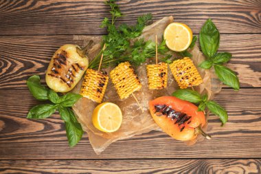 Zeytinyağı, biber, tuz ve fesleğen parşömen kağıt üzerine karanlık bir yüzey üzerinde Mısır pişmiş. Vejeteryan, vejeteryan menü