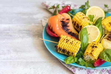 Zeytinyağı, biber, tuz ve fesleğen ışık bir yüzeye mavi çanak üzerinde Mısır pişmiş. Vejeteryan, Vejeteryan menü