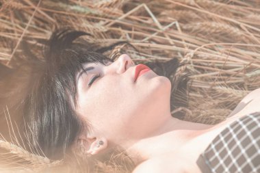 Portre uyuyan sevimli mutlu güzel kadın esmer kırmızı ruj günbatımı zamanını, buğday alanının bir arka plan ile. Alan, tonda ve işleme fotoğraf sığ derinliği.