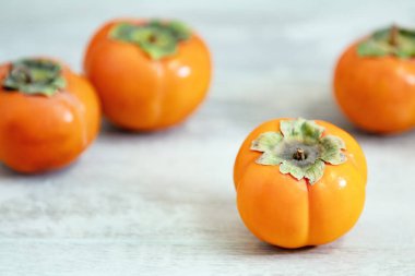 Sonbaharda hasat Trabzon hurması ahşap masa arka plan üzerinde kase meyve. Uzay kopyalayın. Hafif stil. Doğal ilaç