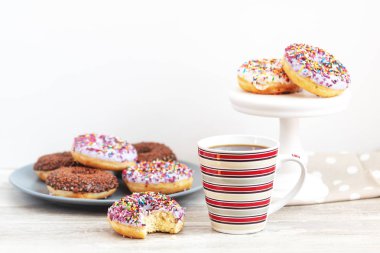 Lezzetli sırlı çörek ve kahve ışık ahşap zemin üzerinde. Güzel romantik kahvaltı ve öğle yemeği kavramı. Sığ derinlik-in tarla.