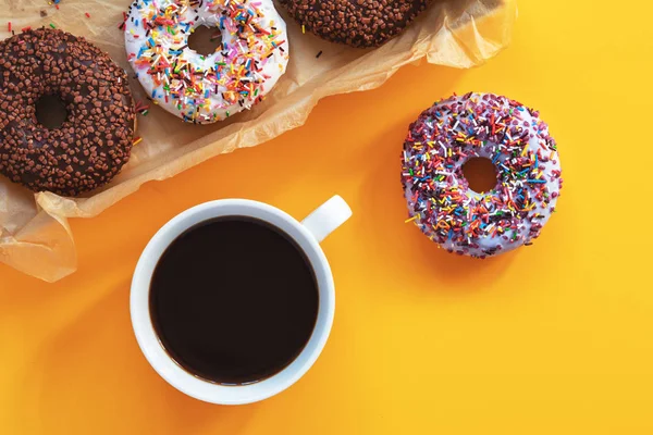 Lezzetli sırlı çörek kutusu ve kahve sarı yüzeyi. Düz yatıyordu minimalist gıda sanat arka plan. Üstten görünüm.