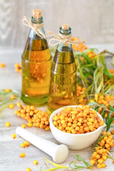 Doğal, organik Deniz topalak meyve beyaz seramik harç ve deniz cehri yağ içinde açık gri ahşap renkli cam vintage şişe