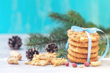 Lezzetli fıstık kurabiye, fıstık, çam dalları ve çam kozalakları masa lambası ve mavi arka plan ile Noel ve yeni yıl kompozisyon. 
