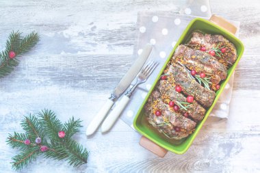 Noel ve yeni yıl kompozisyon ile lezzetli pişmiş et kızılcık ve baharatlar, dalları, çatal bıçak takımı ışık gri yüzeyi, kopya baharat, tatil arka plan, Noel tablo yer ayarını çeki düzen vermek