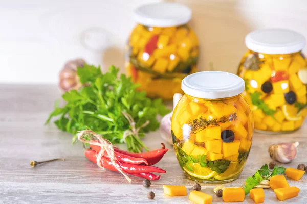 Marine edilmiş konserve kavanoz. Ev yapımı turuncu kırmızı sıcak biber, taze maydanoz, baharatlar ışık gri ahşap arka plan üzerinde ile kabak turşu kesti. Fermente gıda.