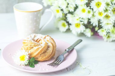 Beyaz masa, sonbahar beyaz kasımpatı ve kahve pembe plaka üzerinde Hindistan cevizi cips lezzetli pasta. Ailece kahvaltı. Metin, kopya alanı için boş alan.