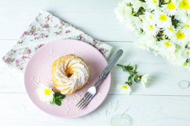 Beyaz masa üzerinde pembe plaka üzerinde Hindistan cevizi cips ile lezzetli kek