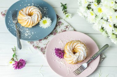 Beyaz masa, sonbahar kasımpatı pembe ve gri tabakta üzerine Hindistan cevizi cips ile lezzetli kek. Ailece kahvaltı. Metin, kopya alanı için boş alan.