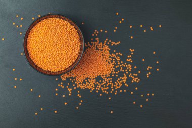 Kırmızı mercimek siyah plaka siyah taş üzerinde arka plan masa. Üstten görünüm, kopya alanı.