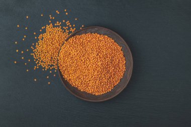 Kırmızı mercimek siyah taş seramik tabak içinde arka plan masa. Üstten görünüm, kopya alanı.