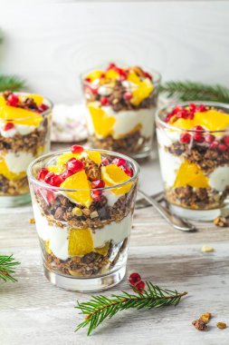 Gri ahşap masa lambası, kopya alanı, sığ derinlik-in tarla günü sağlıklı kahvaltıda granola, portakal ve nar meyve ile Yunan yoğurt.