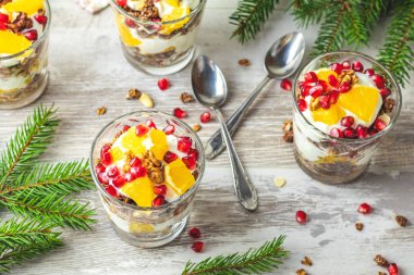 Gri ahşap masa lambası, kopya alanı, sığ derinlik-in tarla günü sağlıklı kahvaltıda granola, portakal ve nar meyve ile Yunan yoğurt.