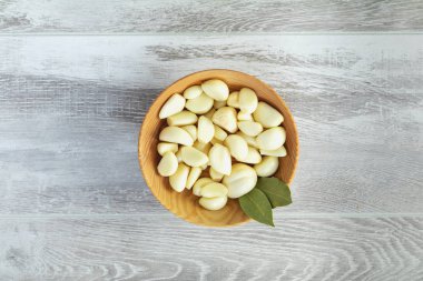 Taze sarımsak başları, plaka üzerinde bir ışık gri ahşap yüzey en iyi görünüm, karanfil kümesindeki alan, boş alan için metin kopyalama.