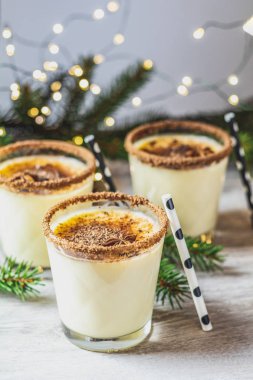 Noel ve kış tatillerinde tarçınlı yumurta likörü ve hindistan cevizi. Ahşap masa yüzeyinde gözlüklü ev yapımı eggnog, alanın sığ derinliği, kopyalama alanı.
