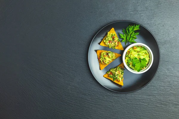 Guacamole Nachos Přísadami Pozadí Černou Kamennou Desku Pohled Shora Kopie — Stock fotografie