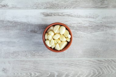 Taze sarımsak başları, plaka üzerinde bir ışık gri ahşap yüzey en iyi görünüm, karanfil kümesindeki alan, boş alan için metin kopyalama.